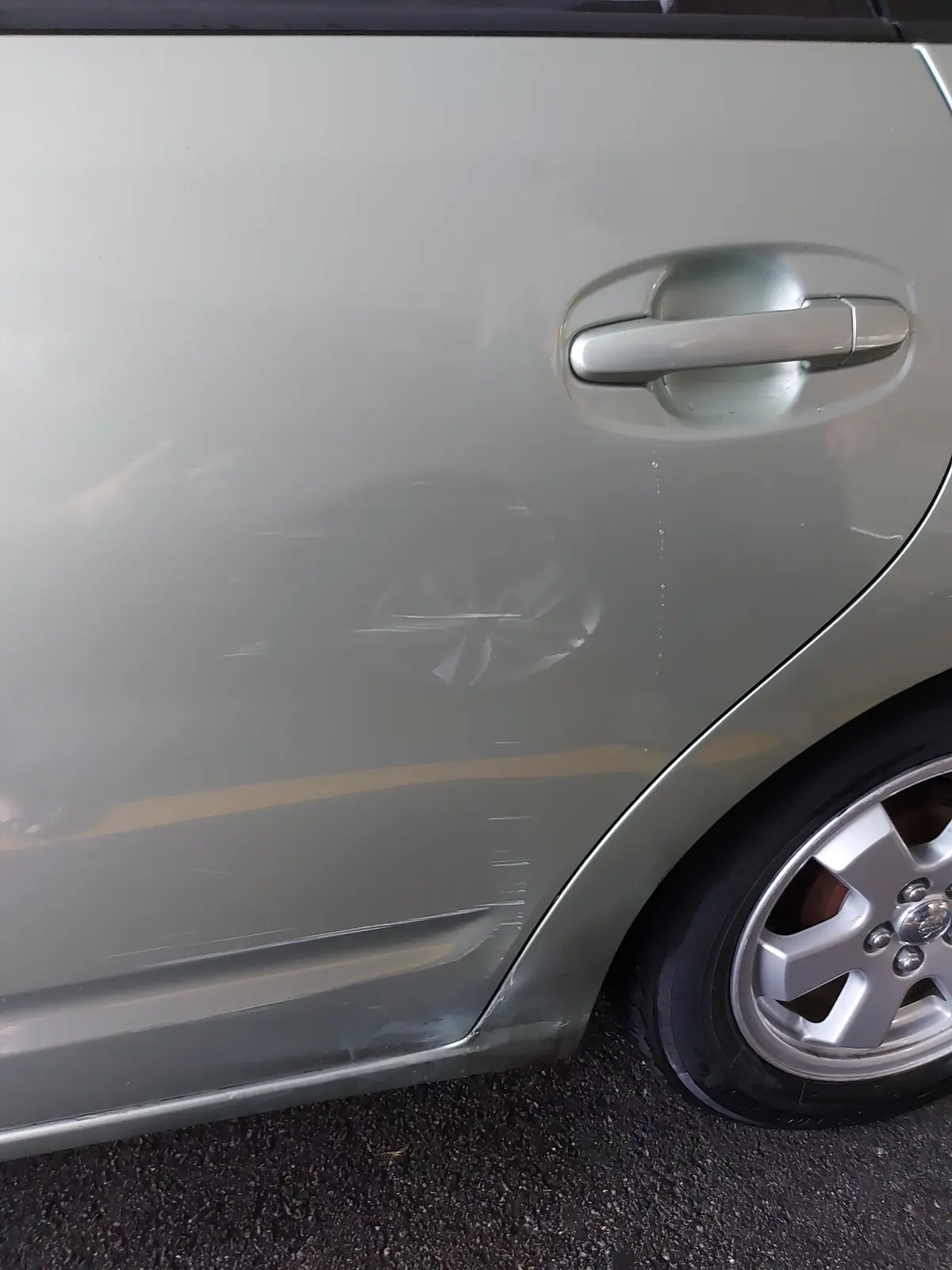 Dented rear door on a Toyota before repair at AutoStyle Collision Scarborough